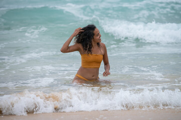 Fototapeta na wymiar Happy woman seen in water as waves rush in