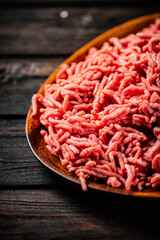A wooden plate full of minced meat.