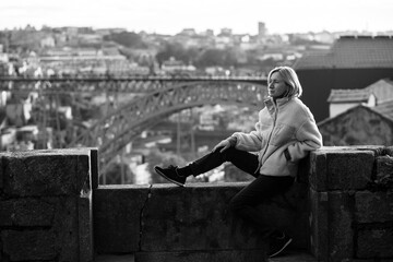 Woman on a stone fortress in the downtown, Porto, Portugal. Black and white photo.