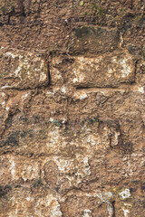 Old damaged mudbrick wall of an old ruined house as background