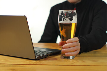 person holding a mug in front of a laptop