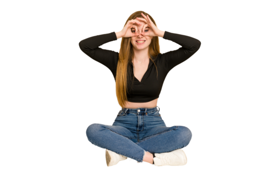 Young redhead woman sitting on the floor cut out isolated showing rock gesture with fingers