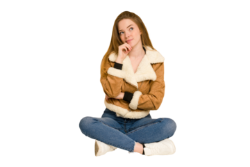 Young redhead woman sitting on the floor cut out isolated throwing a punch, anger, fighting due to an argument, boxing.