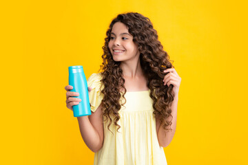 Obraz premium Happy portrait of child with shampoo conditioner. Daily cosmetic care. Teenager kid 12, 13, 14 years old hold bottle of hair and skin care. Beauty health and cosmetics. Smiling girl.