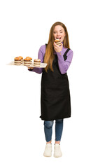 Full body of a young redhead woman  holding a recently made muffins cut out isolated