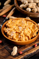 Peanut butter and inshell peanuts in wooden plates. 