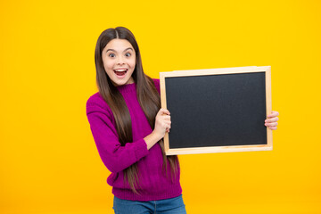 Obraz na płótnie Canvas Teenager child holding blank chalkboard for message Isolated on a yellow background. Empty text blackboard, copy space mock up.