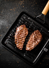 Delicious grilled steak in a frying pan. 