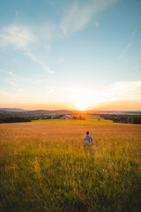 Man sitting in a cornfield thinks about his future looking into the sunset. Self-education, mastering mindfulness. Beskydy mountains, Czech Republic