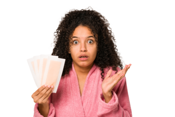 Young african american curly woman holding an hair removal bands isolated surprised and shocked.