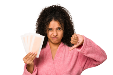 Young african american curly woman holding an hair removal bands isolated showing a dislike gesture, thumbs down. Disagreement concept.