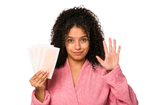 Young african american curly woman holding an hair removal bands isolated smiling cheerful showing number five with fingers.