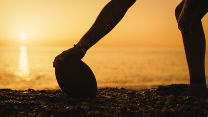 Playing football on the beach at sunset