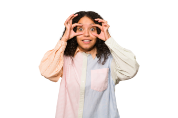 Young african american curly woman isolated keeping eyes opened to find a success opportunity.