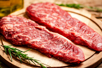 Raw steak on a wooden cutting board. 