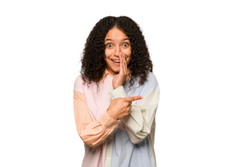 Young african american curly woman isolated saying a gossip, pointing to side reporting something.