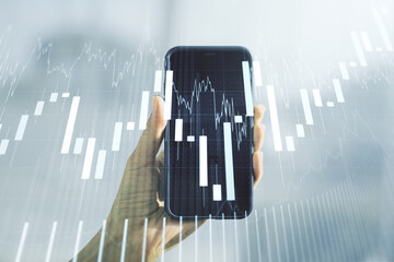 Multi exposure of abstract financial graph and hand with mobile phone on background, financial and...