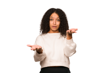 Young african american curly woman isolated makes scale with arms, feels happy and confident.
