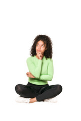 Young african american curly woman sitting on the floor isolated