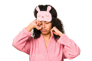 Young african american curly woman wearing a sleep mask isolated