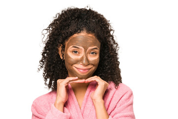 Young african american curly woman wearing a bathrobe and a facial mask isolated