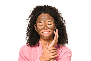 Young african american curly woman wearing a bathrobe and a facial mask isolated