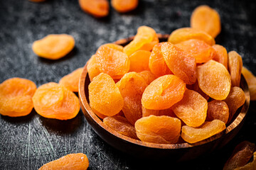 Delicious dried apricots in a wooden plate. 