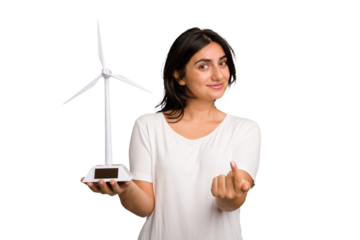 Young Indian woman holding a small wind energy mill isolated pointing with finger at you as if inviting come closer.