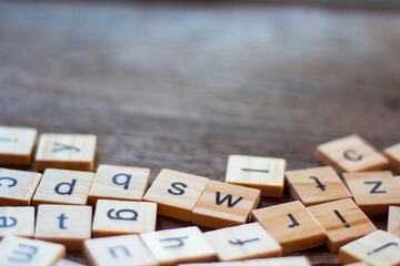 English alphabet made of square wooden tiles with the English alphabet scattered on table. The...