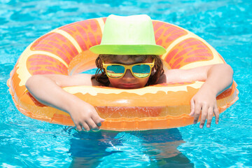 Child boy splashing in swimming pool. Swim water sport activity on summer vacation with children.