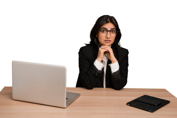 Young indian woman in a table with a laptop and tablet isolated praying for luck, amazed and opening mouth looking to front.