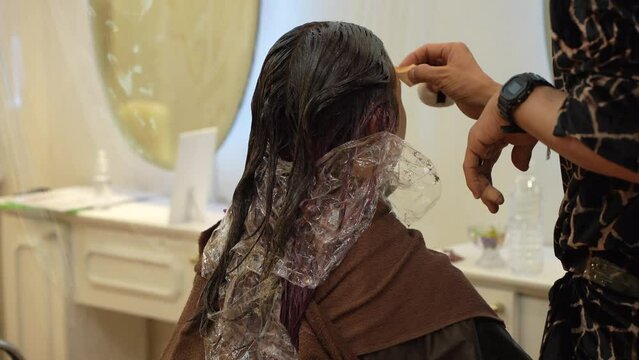 女性にメイクをする男性美容師