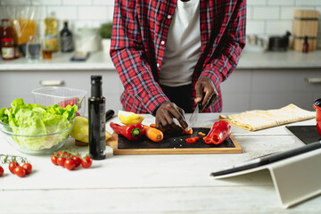 African man cooking in modern kitchen. Handsome chef preparing food..
