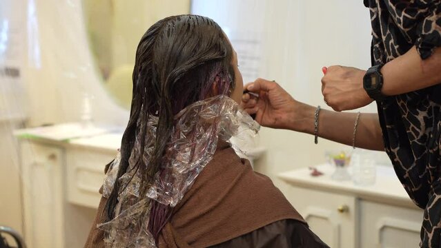 女性にメイクをする男性美容師