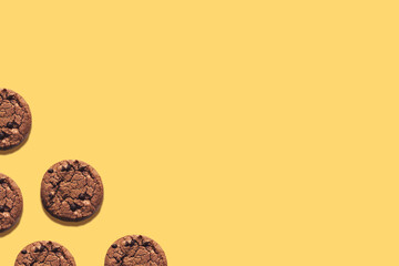 Chocolate chips cookies on yellow background. Top view design concept with copy space. Homemade oatmeal biscuits on bright desk. Minimal style