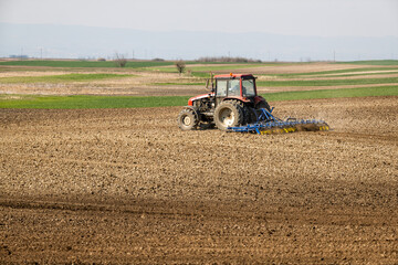 Fototapeta premium Farming's gentle touch, tractor cultivating the land with care