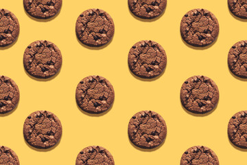 Fototapeta na wymiar Homemade chocolate chips cookies on yellow background. Top view photo. Pattern with oatmeal biscuits on bright desk. Minimal style