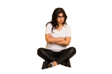 Young indian woman sitting on the floor cut out isolated unhappy looking in camera with sarcastic expression.