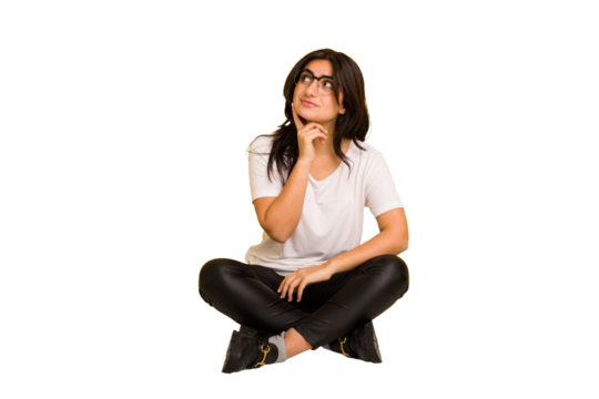 Young indian woman sitting on the floor cut out isolated contemplating, planning a strategy, thinking about the way of a business.