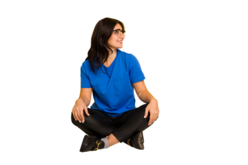 Young indian woman sitting on the floor cut out isolated looks aside smiling, cheerful and pleasant.
