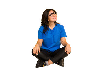 Young indian woman sitting on the floor cut out isolated relaxed and happy laughing, neck stretched showing teeth.