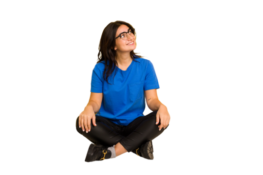 Young indian woman sitting on the floor cut out isolated relaxed and happy laughing, neck stretched showing teeth.