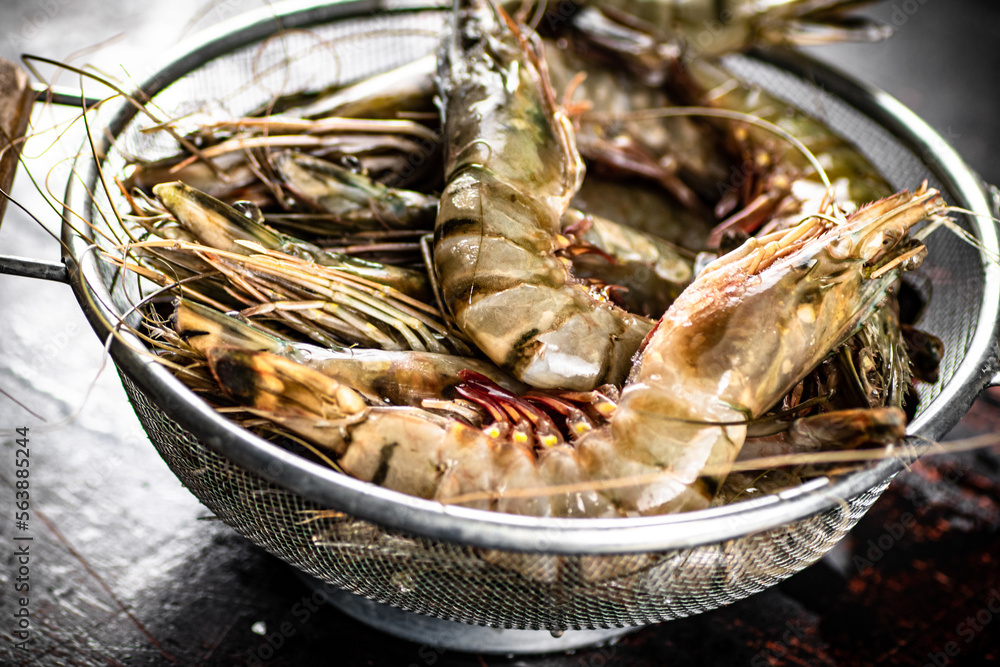 Poster Fresh uncooked shrimp in a colander. 