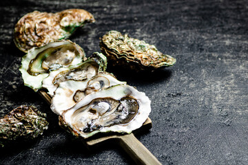 There are fresh oysters on the cutting board. 