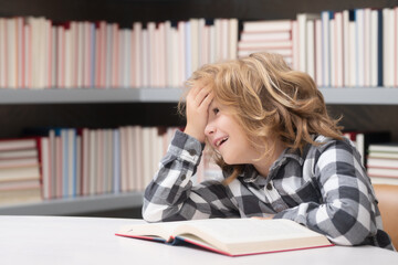 Childhood and education concept. Child reading book in a book store or library,