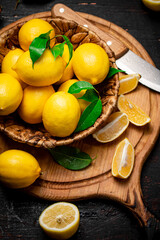 Obraz na płótnie Canvas Ripe lemons in a basket on a cutting board. 