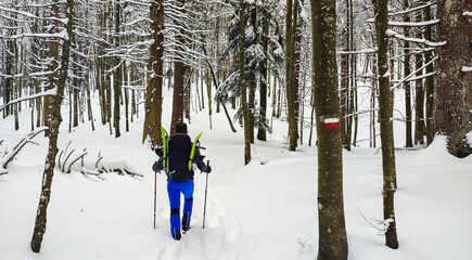 Giovane alpinista in escursione invernale in ambiente innevato nell'appenino italiano. Ciaspolata sui monti innevati in Italia.