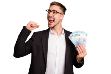Young business caucasian man holding euro banknotes isolated cut out raising fist after a victory, winner concept.