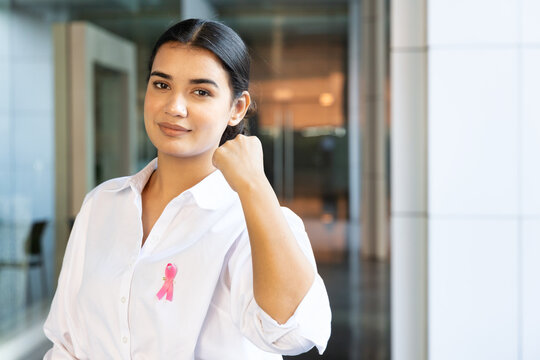 Strong and confident South Asian woman with pink ribbon, concept of love and care in breast cancer awareness day or month