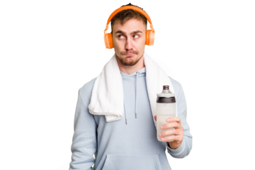 Young caucasian sporty man ready to start his gym day confused, feels doubtful and unsure.